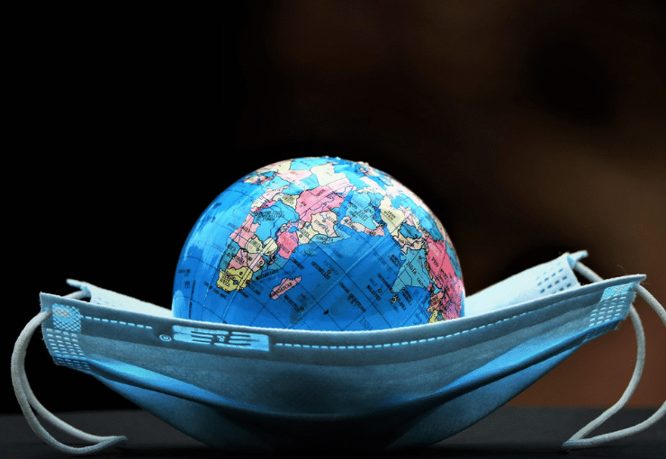 Image of a small globe laying on top of a mouth mask