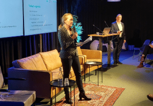 Photo of Barbara from Wemos in the front and Arnold from Tax Justice NL, on stage moderating a session at the Afrikadag at Pakhuis De Zwijger.