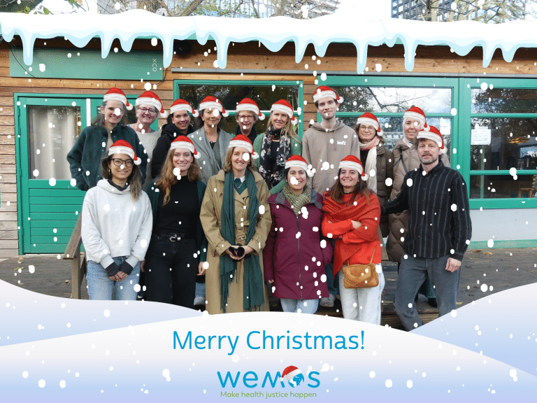 Photo of the Wemos team with Santa hats standing outside and snow flakes falling down. At the bottom the words: Merry Christmas!